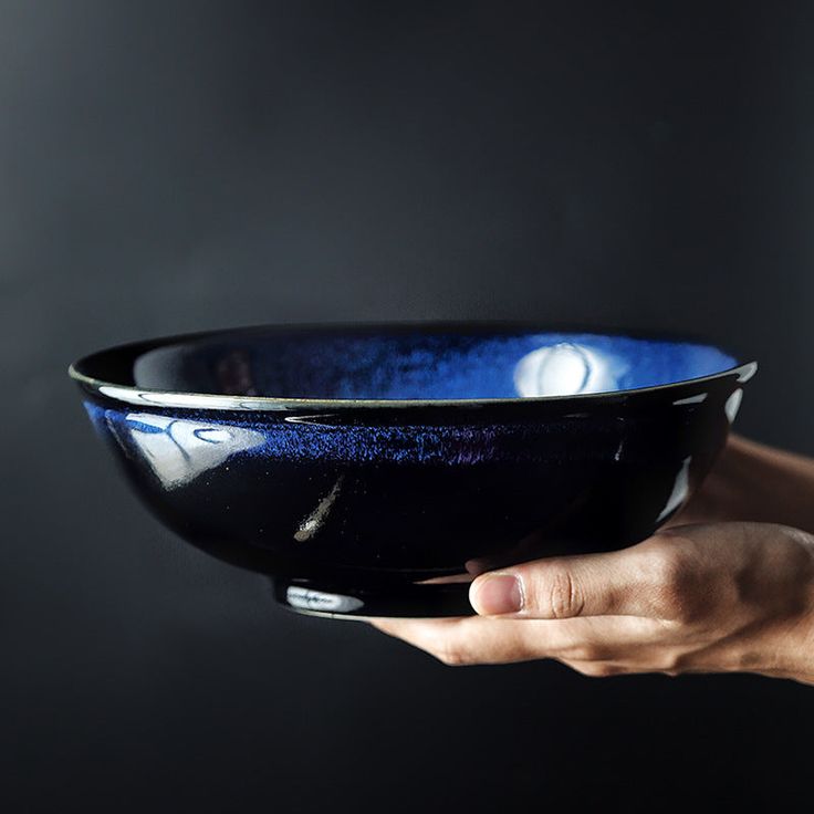 a person holding a blue bowl in their hand