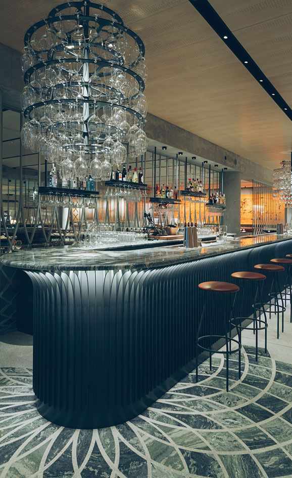 an elegant bar with chandelier and stools