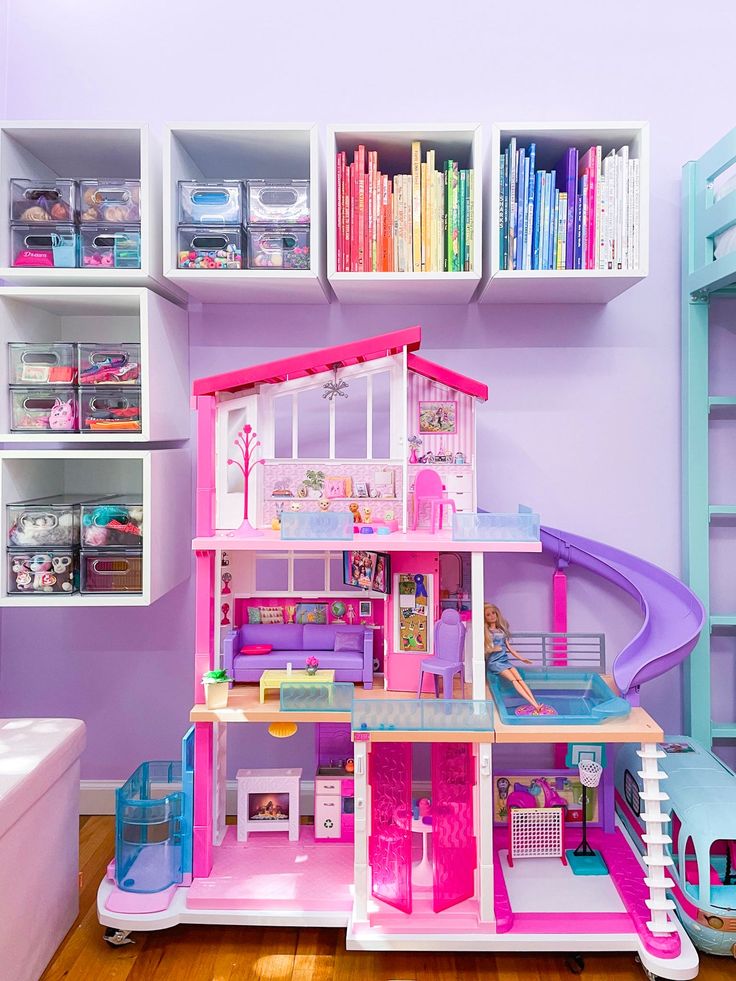 there is a doll house in the room with many shelves and toys on the floor