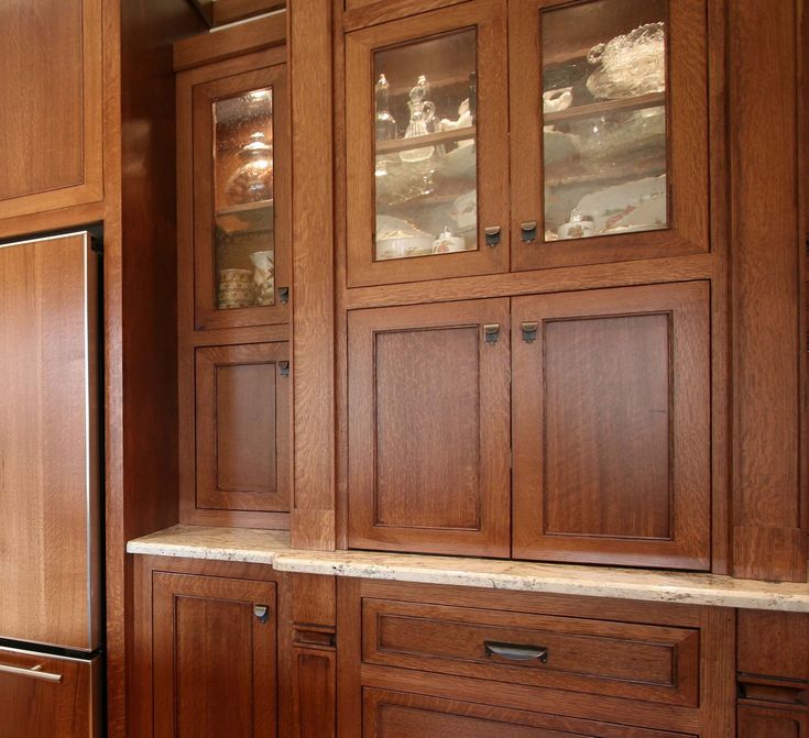 a kitchen with wooden cabinets and marble counter tops