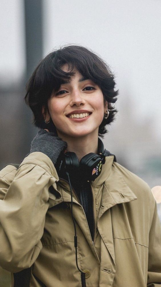 a woman wearing headphones is smiling for the camera