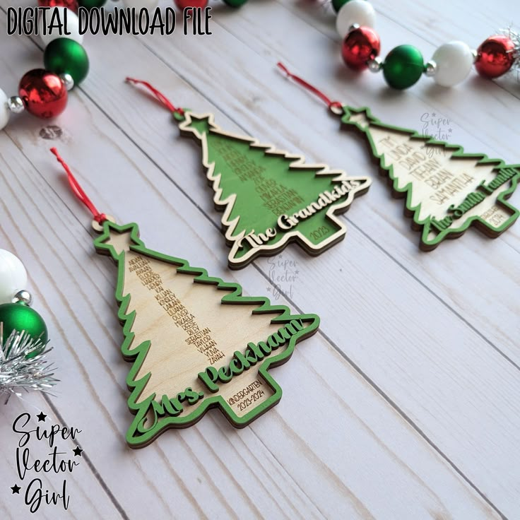 three wooden christmas tree ornaments on a white wood table with red and green baubles