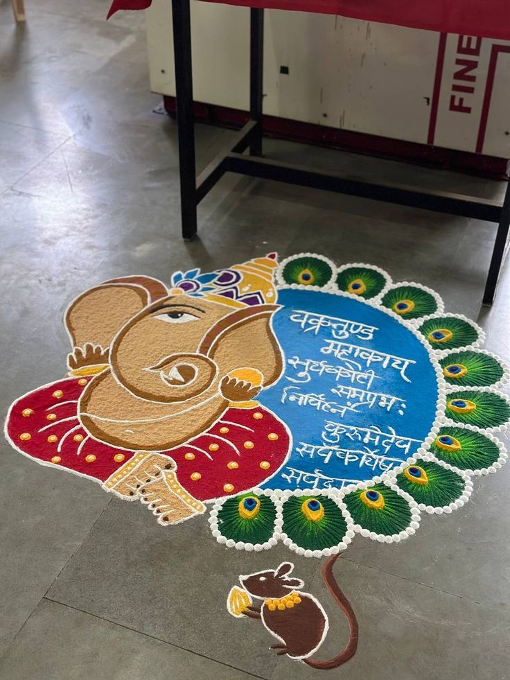 an elephant is sitting on the ground with a sign in front of it that says ganesh