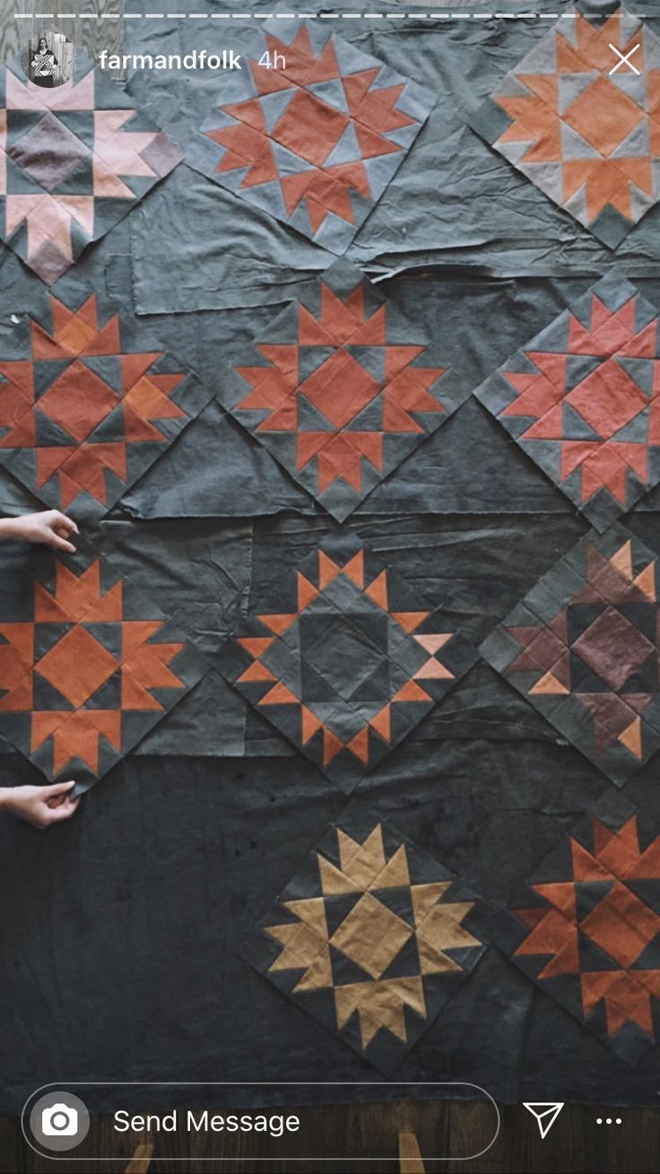 someone is holding up a quilt that has been made to look like starbursts