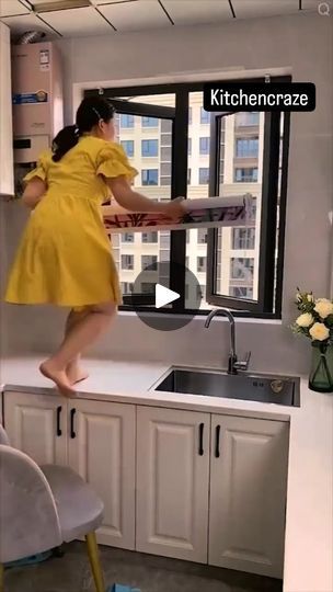 a woman in a yellow dress jumping into a kitchen sink