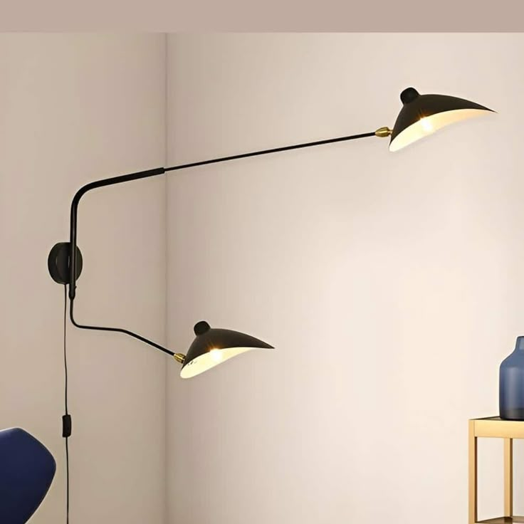 two lamps are on the wall next to a table