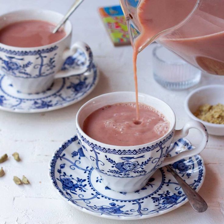 two cups filled with liquid sitting on top of a saucer