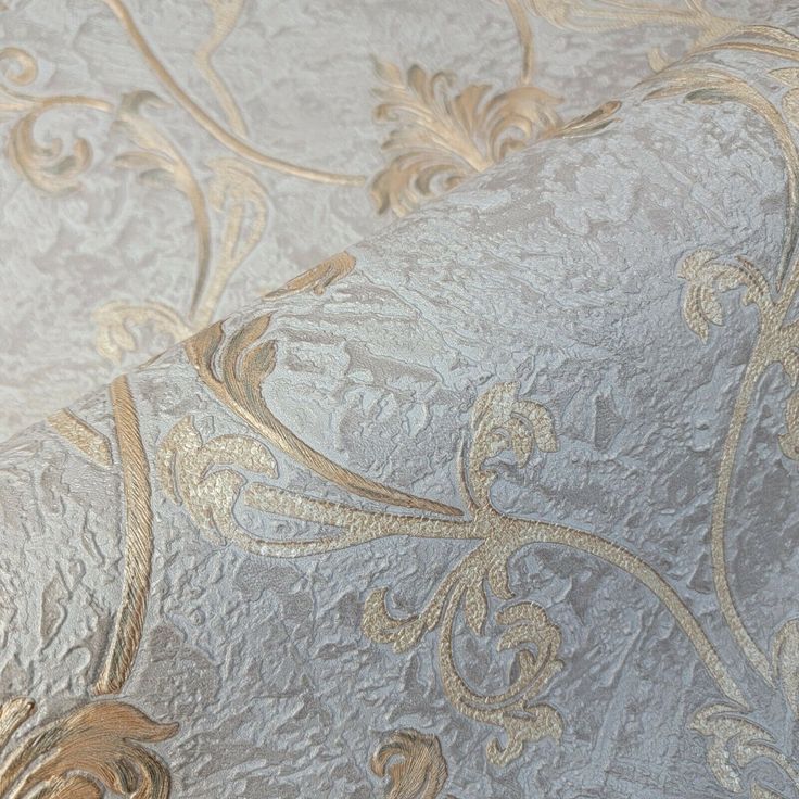 a close up view of a wallpaper with gold and silver designs on the fabric