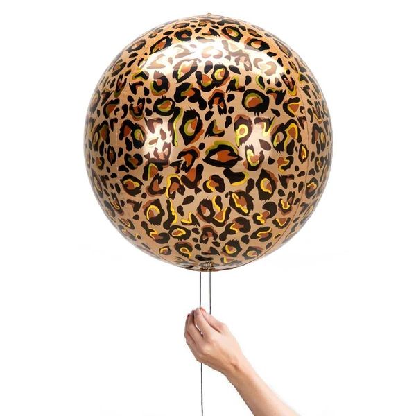 a hand holding a leopard print balloon in the air