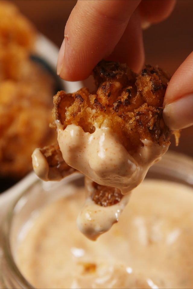 a person dipping some kind of food into a bowl