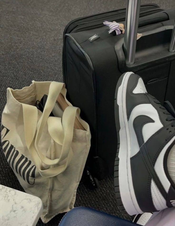 two pieces of luggage sitting on the floor next to each other with their feet propped up