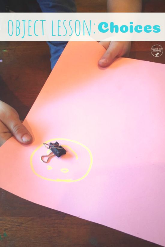 a child is holding a piece of paper with a small toy on top of it