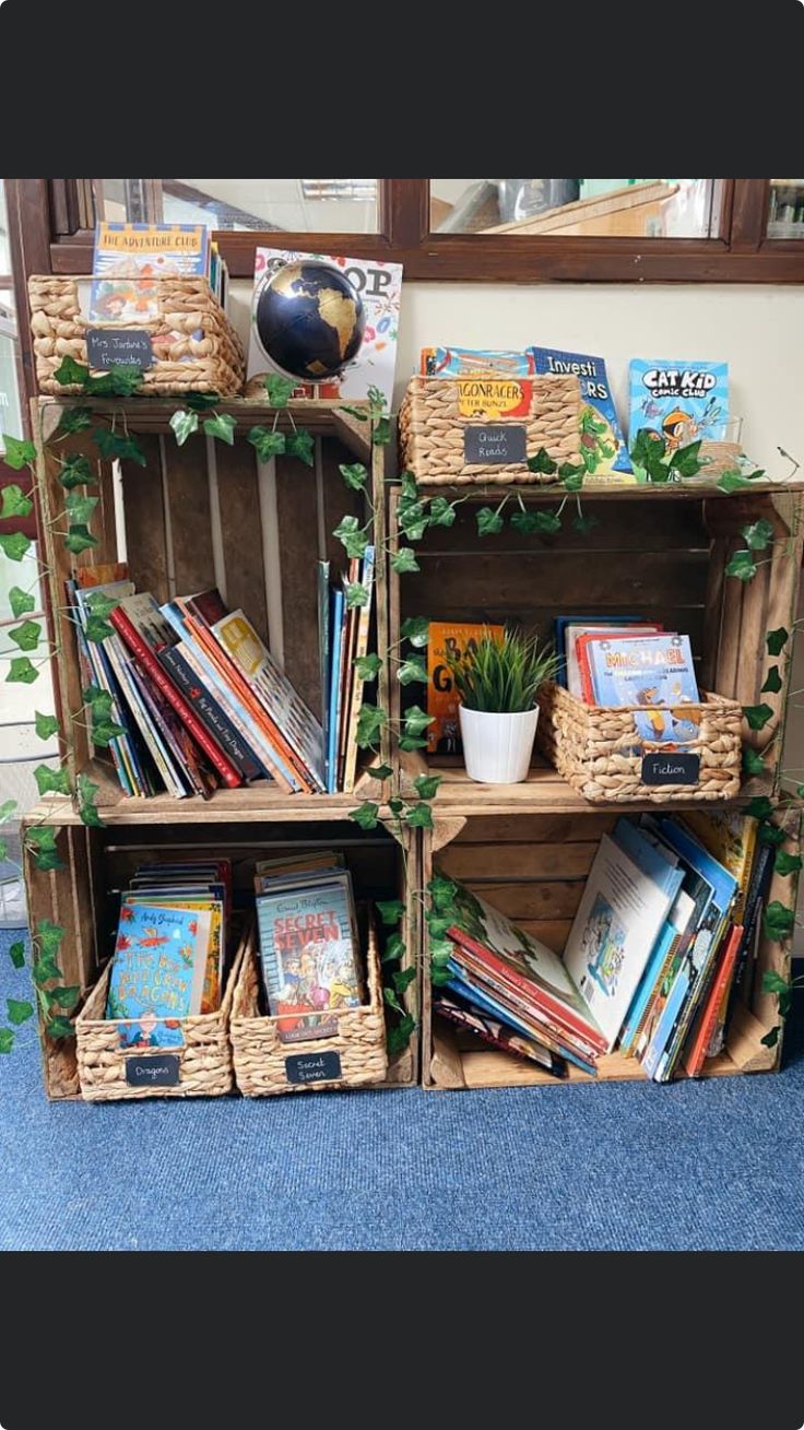 three wooden crates filled with books and plants