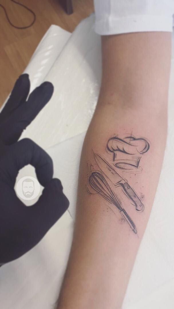 a person with a tattoo on their arm holding a knife and fork in the other hand