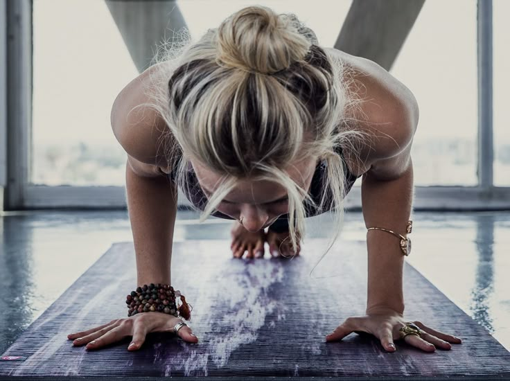 a woman doing push ups on a yoga mat