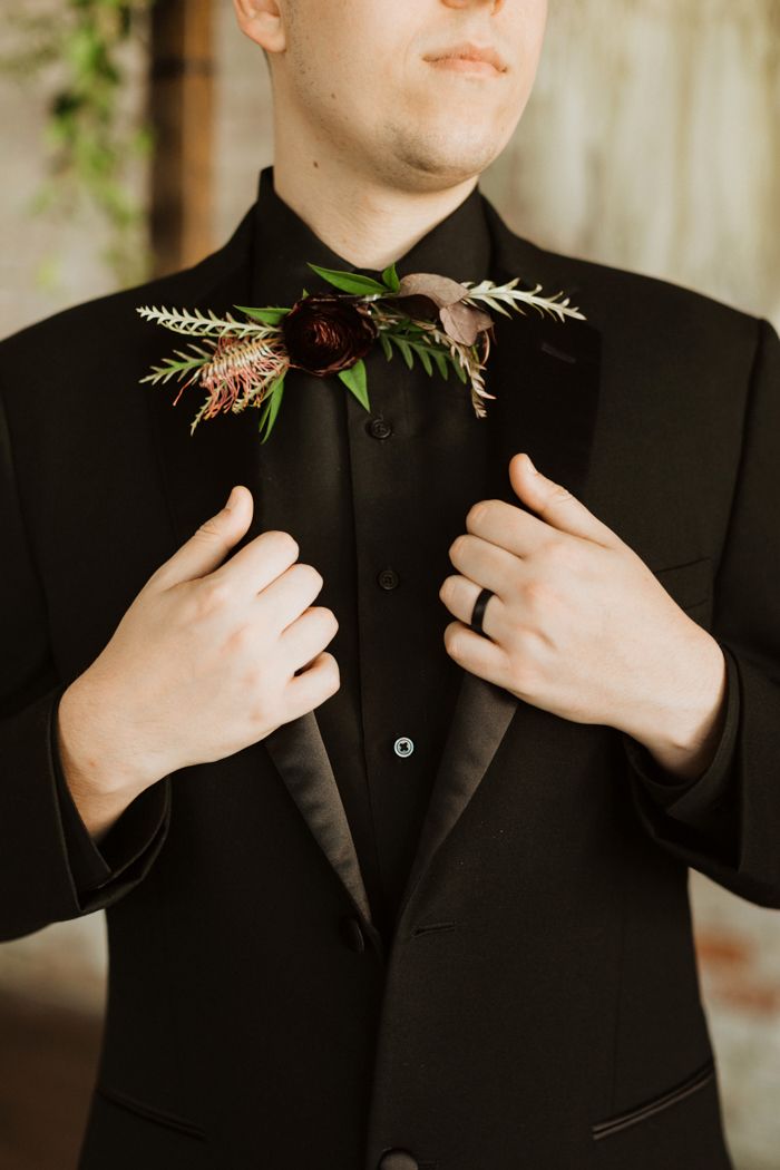 a man in a tuxedo adjusts his bow tie