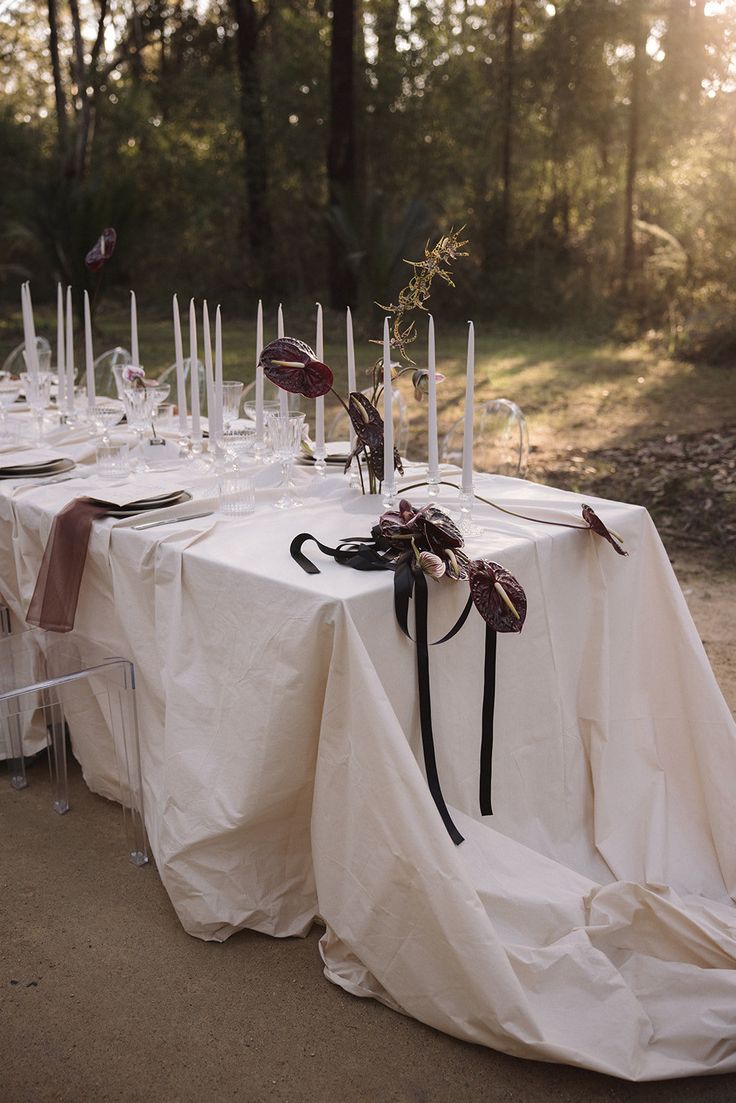 the table is covered with white cloths and candles