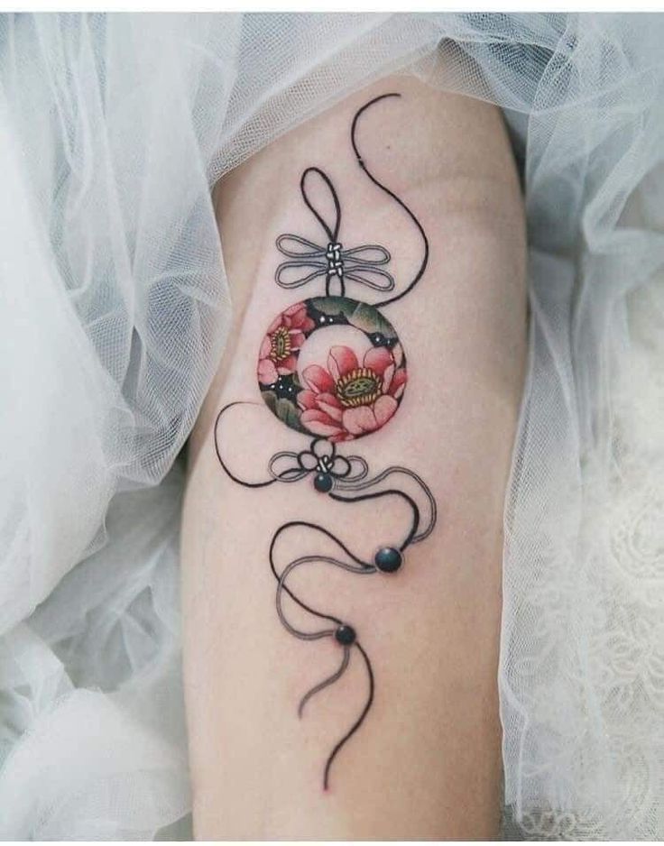 a woman's leg with a dragon tattoo on it and flowers in the center