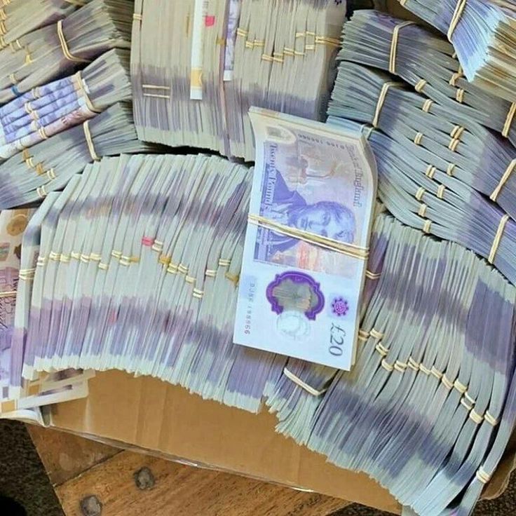 several bundles of money sitting on top of a wooden table