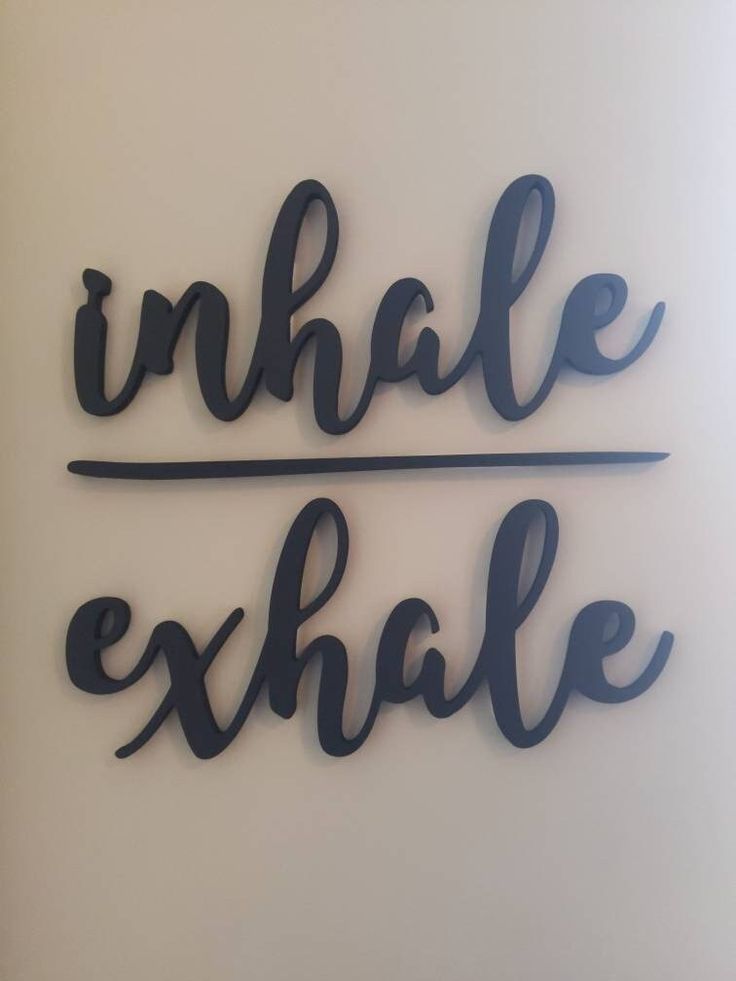 the words inhale and exhale are made out of black wire on a white wall