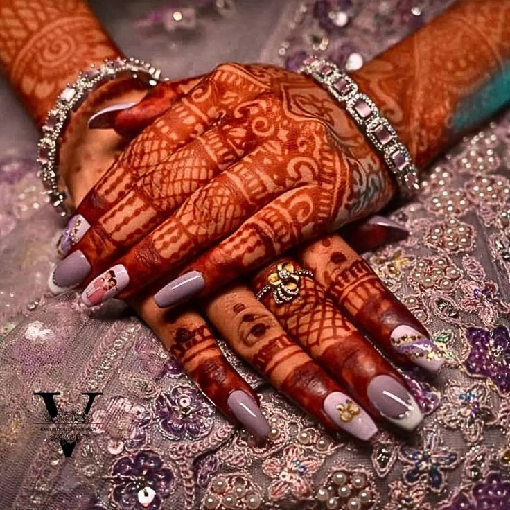 a woman's hands with hennap and rings on them, holding onto her hand