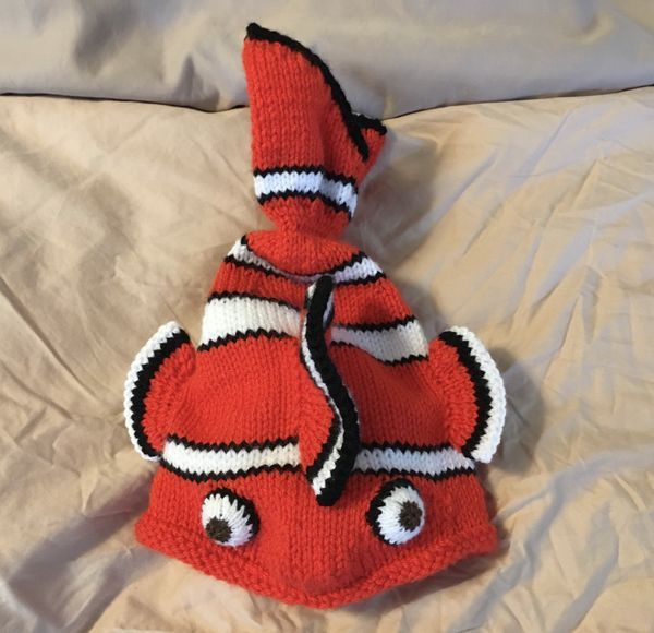 an orange and white knitted hat on top of a bed