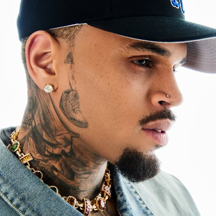 a man with tattoos wearing a baseball cap