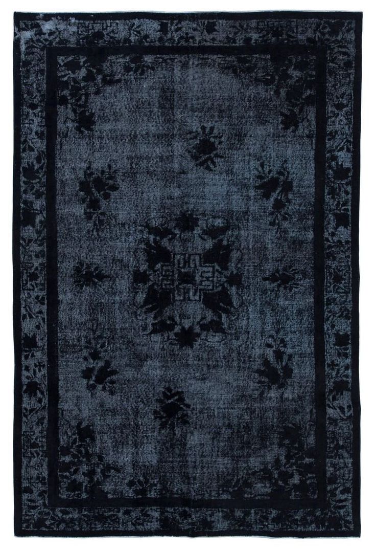 a black and blue rug with an ornate design on the center, in front of a white background