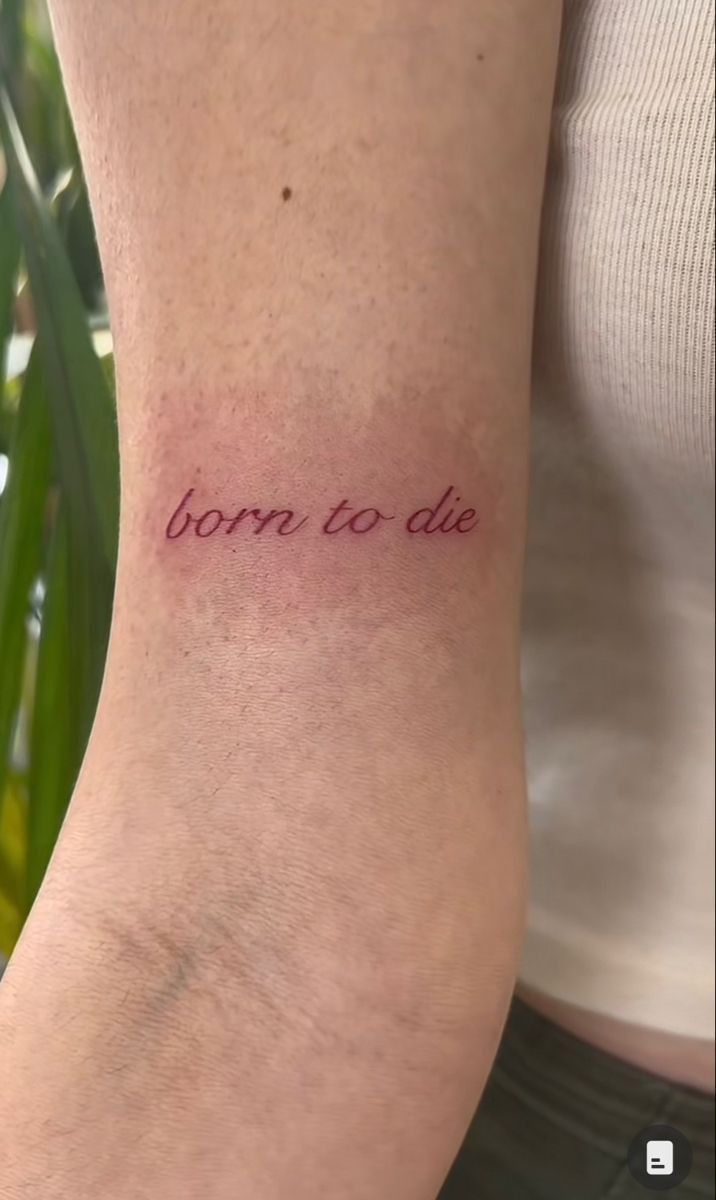 a woman's arm with the words born to die tattooed on her left side