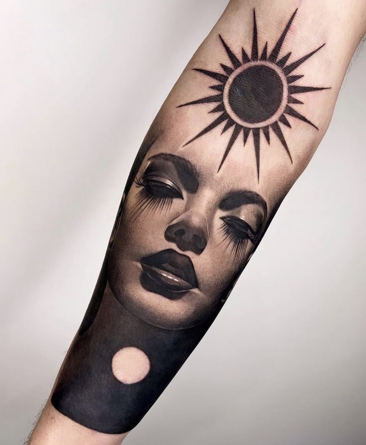 a woman's arm with a sun and moon tattoo design on the left forearm