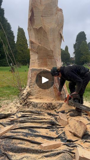 a man is working on a sculpture in the middle of a field with trees and grass