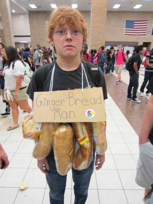 a young boy holding a sign with hot dogs in it's hands while standing on a tiled floor