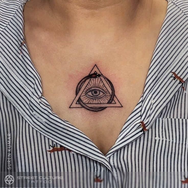 a woman's chest with an all seeing eye tattoo on it