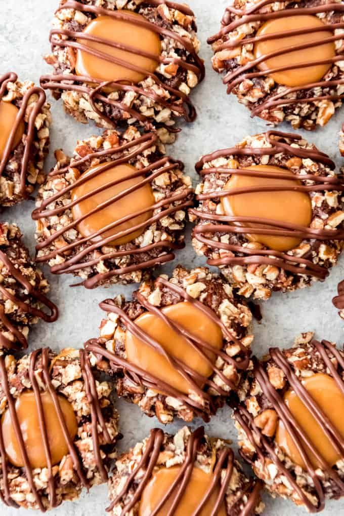 chocolate covered cookies with nuts and caramel drizzled on the top one