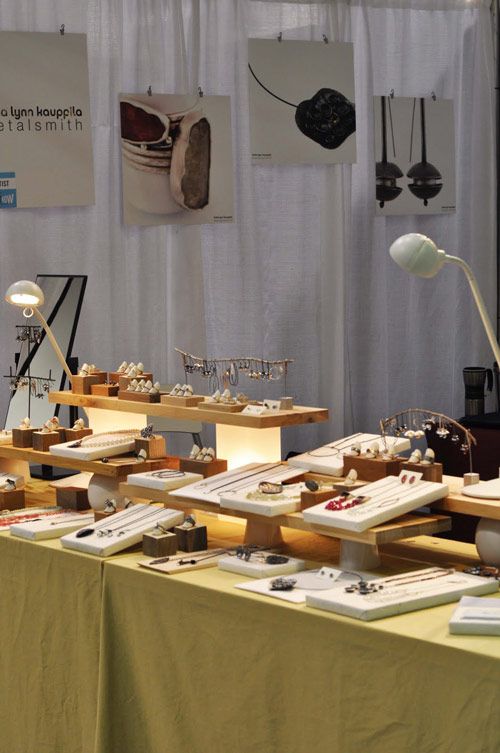 a table topped with lots of desserts on top of wooden tables next to a white curtain