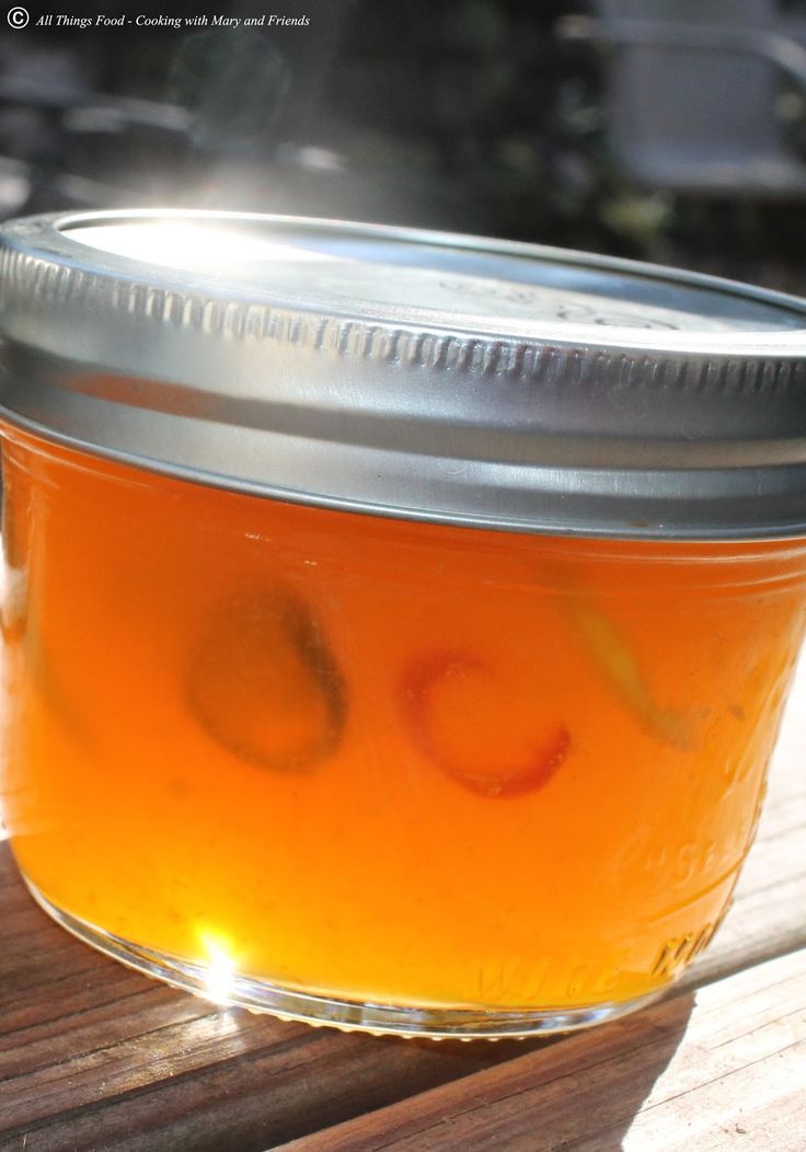 a jar filled with liquid sitting on top of a wooden table