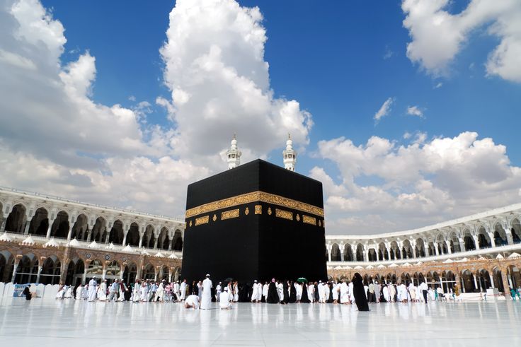 a group of people standing in front of a large black building with gold trimmings