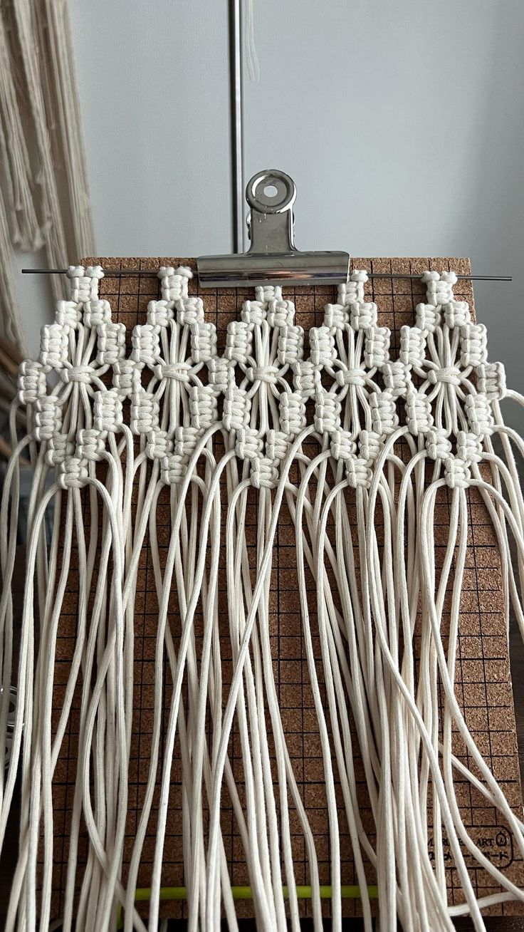 white cords are connected together on a piece of wood with a light fixture in the background