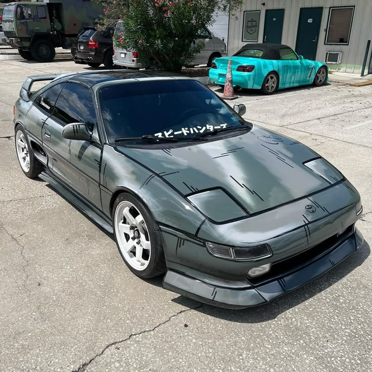 a gray sports car parked in front of a building