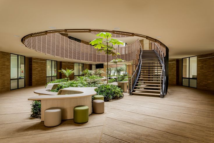 a circular staircase in the center of a room with plants and stools around it