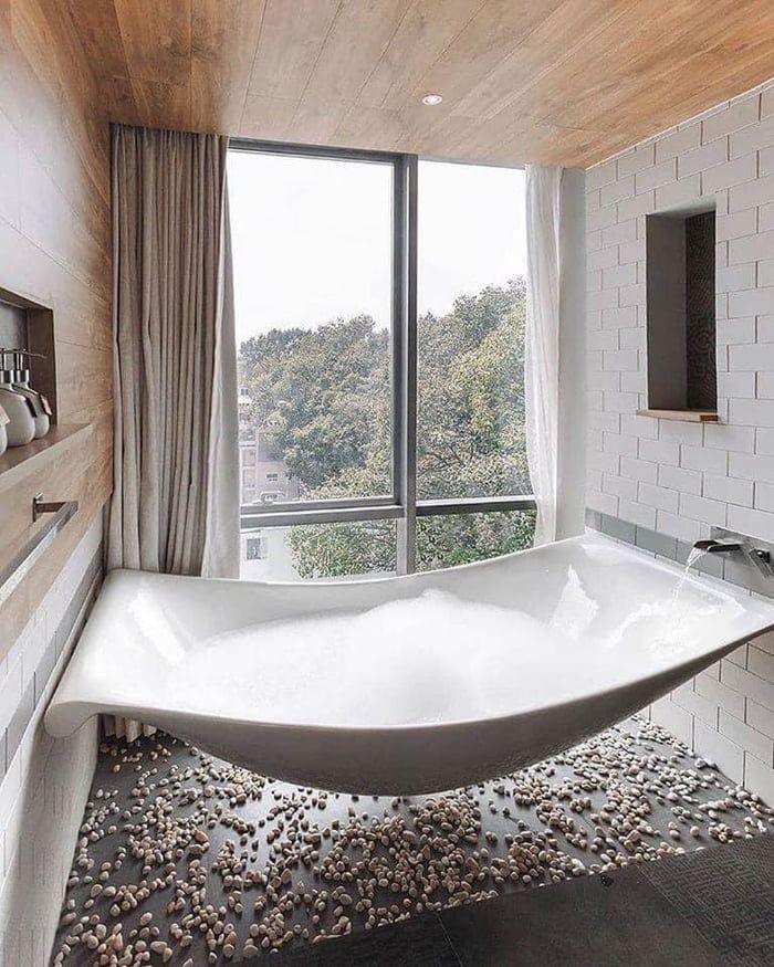 a bathroom with a large bathtub in the middle of it, and an open window