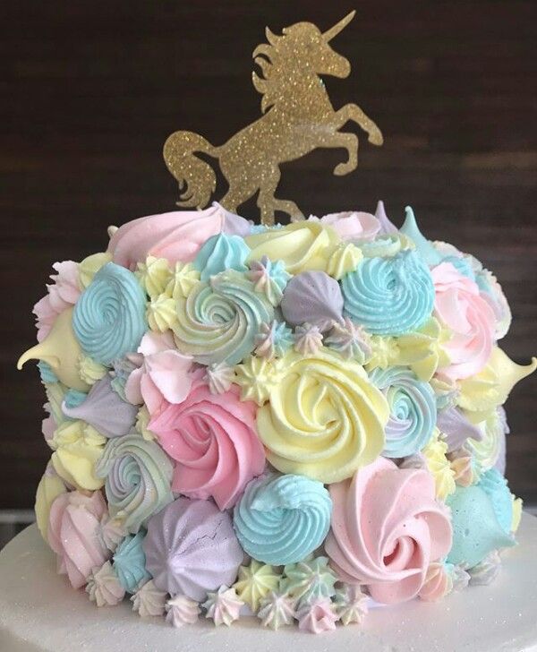 a cake decorated with colorful frosting and a unicorn on top