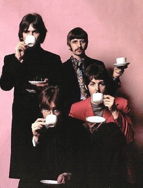 the beatles are drinking coffee together in front of a pink wall with one holding a cup