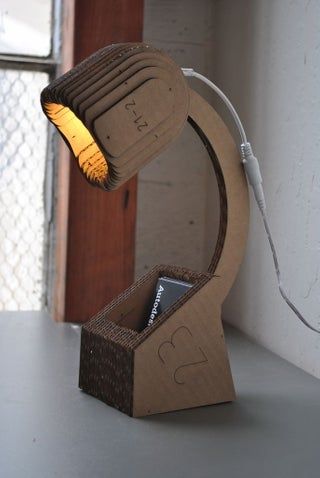 a lamp made out of cardboard sitting on top of a table