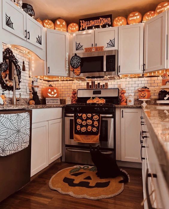 a kitchen decorated for halloween with pumpkins and decorations