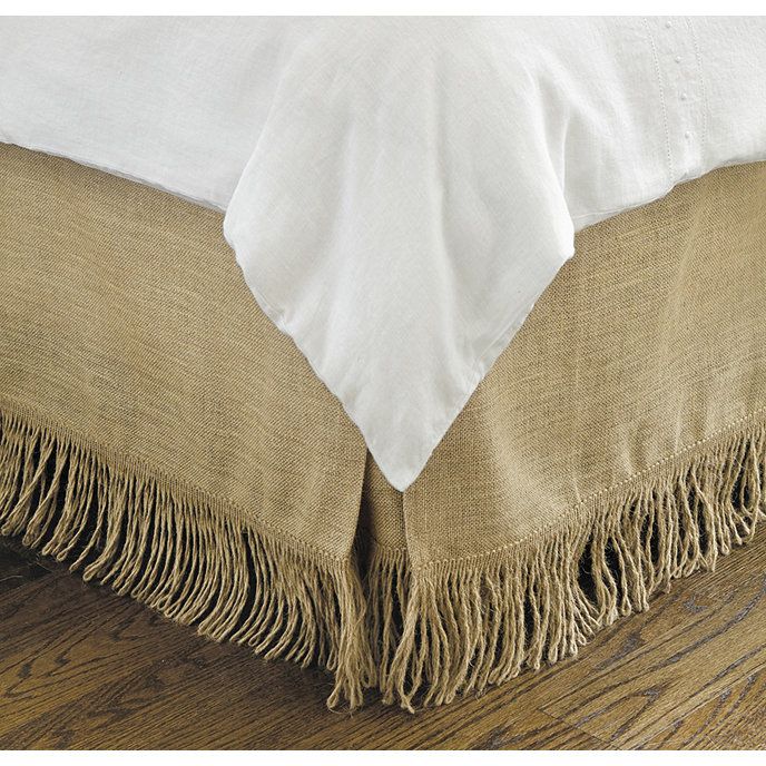 a close up view of a bed with fringed linens on the bottom and sides