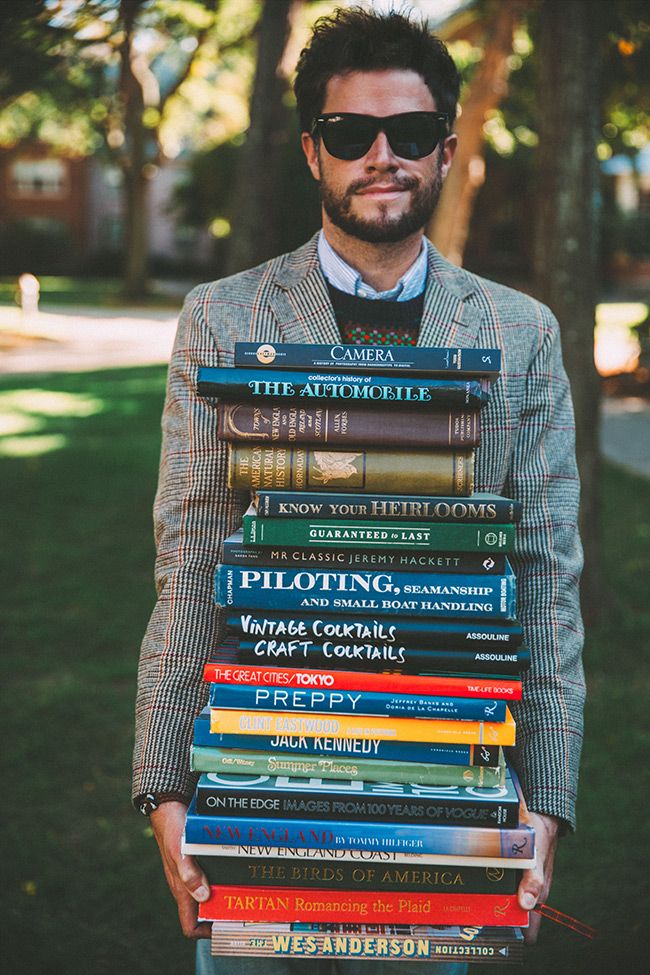 a man holding a stack of books in his hands