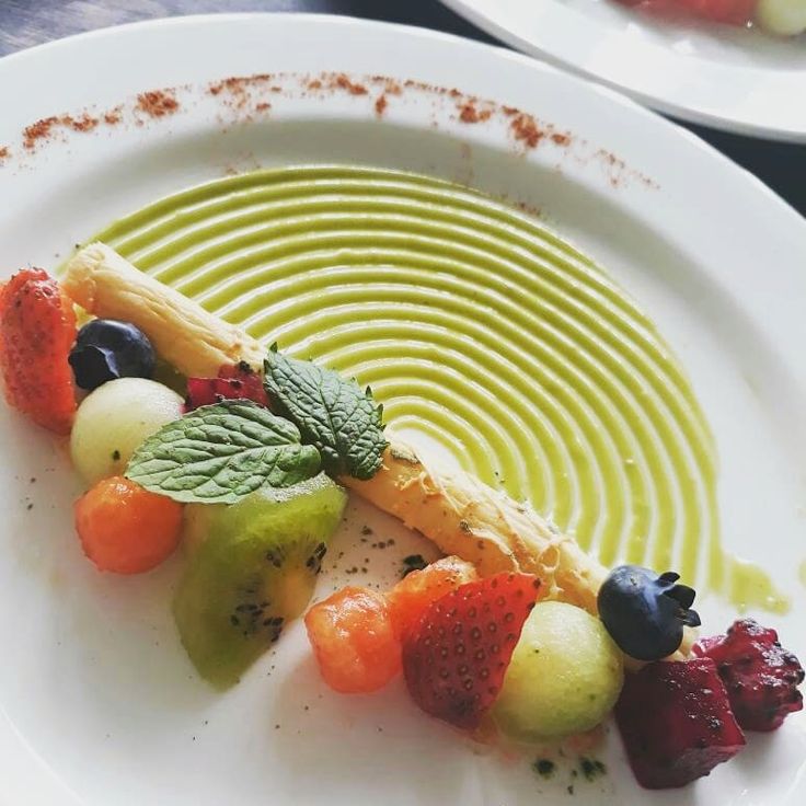 a white plate topped with fruit on top of a table