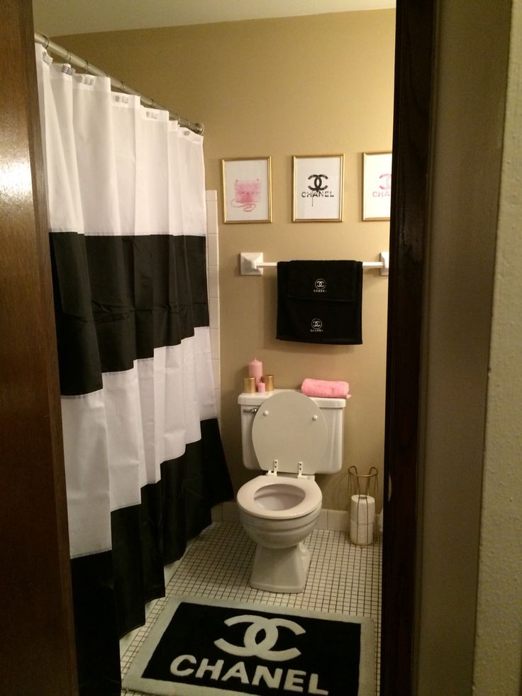 a bathroom with chandelier, toilet and shower curtain in black and white colors