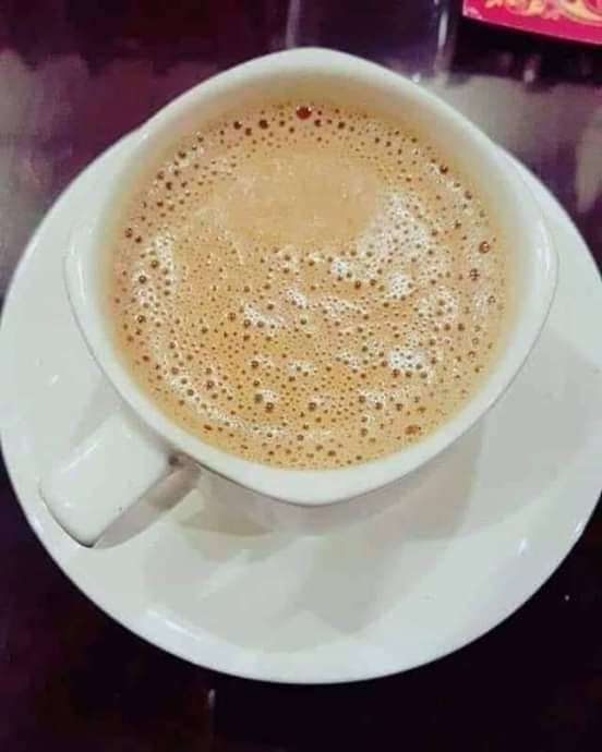 a cup of coffee sitting on top of a white saucer